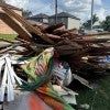 Piles of illegally dumped trash, including furniture, construction debris, and household waste, line a median in Houston.