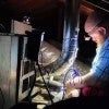 BakerRipley quality assurance manager Jacob Smith tests the ventilation of a gas furnace in the flue.