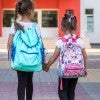Two students walk to elementary school classes.