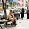 Man sitting on a city bench on his phone. 