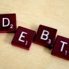 Scrabble letters spelling out "debt"