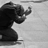 Black and white photo of a man begging for money