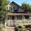 Home with a white picket fence in the front yard Home with a white picket fence in the front yard