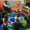 Woman teaching a group of students sitting on the floor