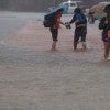 People walking through flooded streets