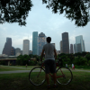 Man holding his bike in front of Houston skyline