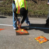 Men spray painting stars on a road