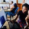 Woman in and office with a man at a computer