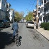 This narrow street, lined with parked cars but devoid of people, is both unwelcoming and unsafe for cyclists. Anne Lusk, CC BY-ND