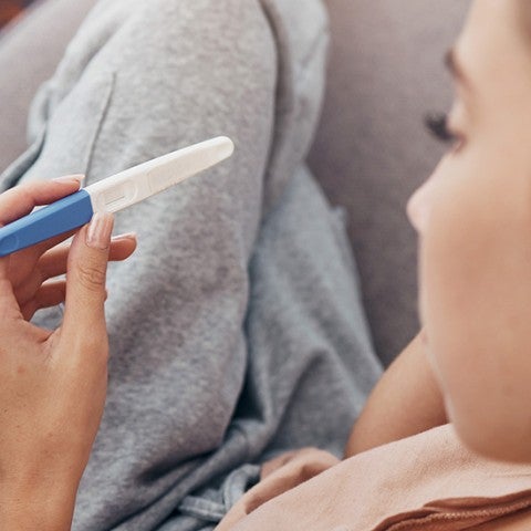 woman looking at a pregnancy test