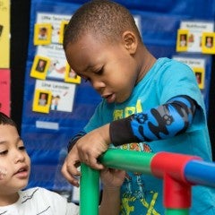 Pre-K students work on a structure in class