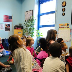 Classroom of students listening to a teach read a book