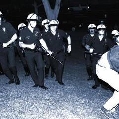 LAPD officers confront a protestor on the south lawn of City Hall while a police car burns during night one of the Rodney King Riots on April 29, 1992, in Los Angeles, California..
